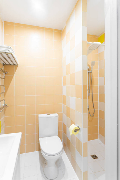 Ванная комната с душем, унитазом и раковиной. Стандартная спальня отеля. простой и стильный интерьер. внутреннее освещение
 - Фото, изображение