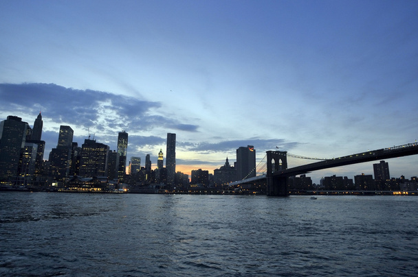 πόλη της Νέας Υόρκης το βράδυ στον ορίζοντα με την γέφυρα του Μπρούκλιν πάνω από τον ποταμό hudson - Φωτογραφία, εικόνα