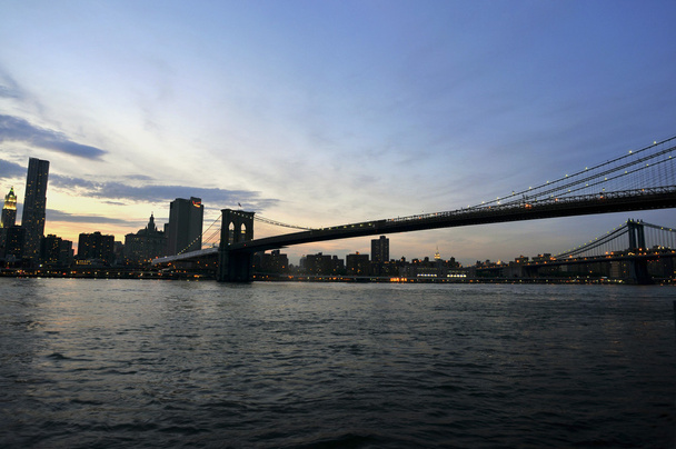 πόλη της Νέας Υόρκης το βράδυ στον ορίζοντα με την γέφυρα του Μπρούκλιν πάνω από τον ποταμό hudson - Φωτογραφία, εικόνα