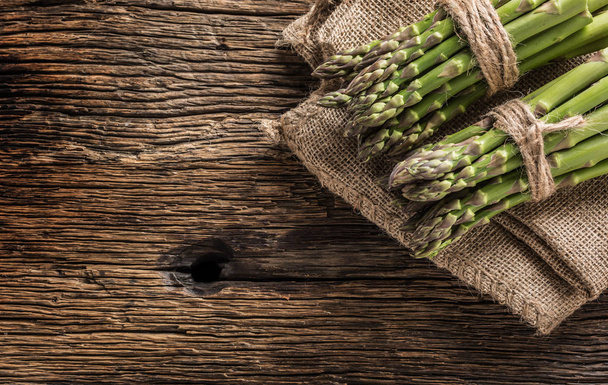 Bunch of fresh asparagus on rustic oak table. - Fotografie, Obrázek