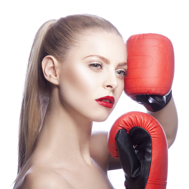 Mulher loira jovem com maquiagem lábios vermelhos e luvas de boxe no fundo branco
 - Foto, Imagem