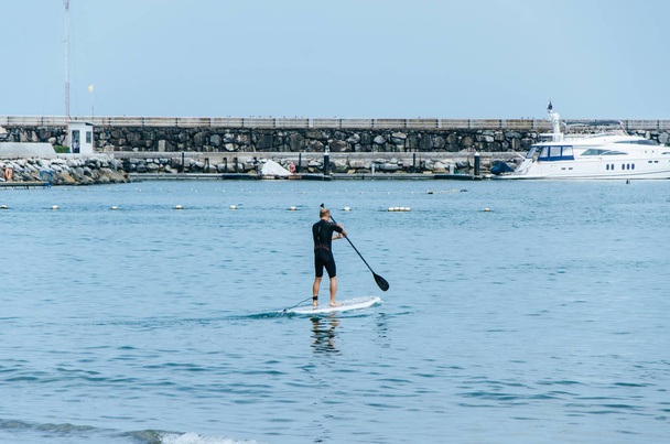Встаньте весло ради людина paddleboarding Перуанський пляж стоячи щасливі на paddleboard на блакитна вода. - Фото, зображення