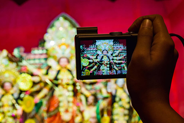 appareil photo à la main prenant des photos de durga idol en arrière-plan faible profondeur de champ
 - Photo, image