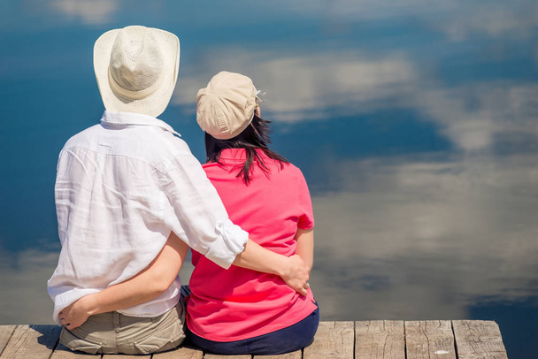 couple heureux étreignant et appréciant le repos près du beau lac, vue de dos
 - Photo, image