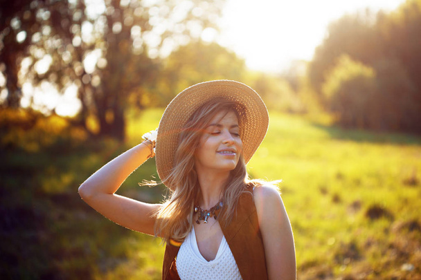 Cute charming girl in summer in the field. Young woman is happy and feels free outdoors - Фото, зображення