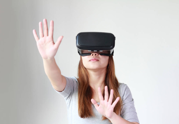Jonge vrouw met virtual reality bril thuis. Een vr headset is een hoofd gemonteerde apparaat waarmee virtuele realiteit voor de drager. - Foto, afbeelding