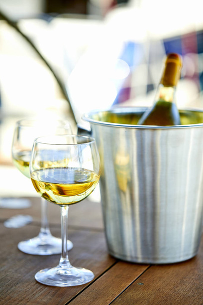 Ζευγάρι wineglasses και κουβά με μπουκάλι σαμπάνιας στο γιοτ - Φωτογραφία, εικόνα