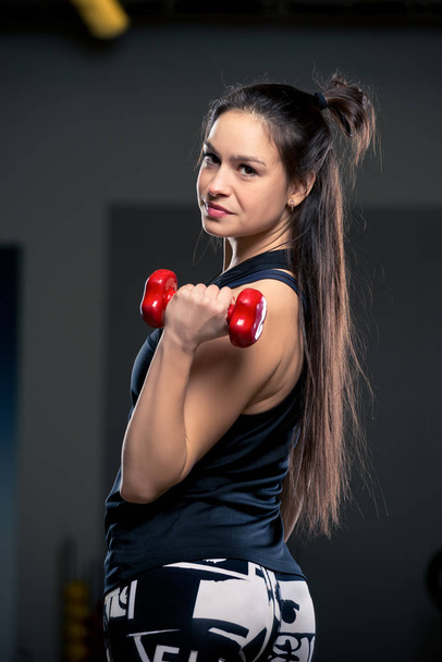 beautiful woman with dumbbells in the gym vertical portrait close-up - Fotoğraf, Görsel