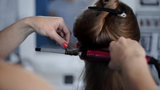 Stylista sprawia, że kręcone fryzury afro dla kobiety przez gorąco curling włosów, proces tworzenia fryzury, fryzury w salonie piękności - Materiał filmowy, wideo