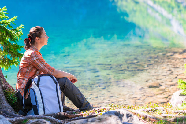 bir sırt çantası ile gezgin tarafından göl Morskie Oko Tatra Dağları'nda oturur ve hayran - Fotoğraf, Görsel