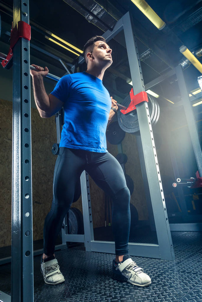 retrato de un atleta en un gimnasio con una barra pesada
 - Foto, Imagen
