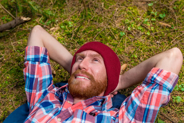 szczęśliwy dreaming forester z czerwoną brodą na leśnej polanie spoczynku - Zdjęcie, obraz