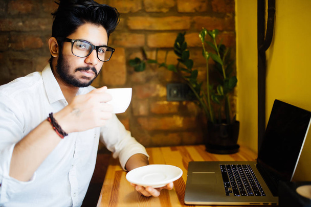 創造的な web ソースから情報を使用する wifi とコーヒー ショップに座って宿題報告のラップトップ コンピューター テキストに入力するハンサムな身なりの男性留学生を集中してください。. - 写真・画像