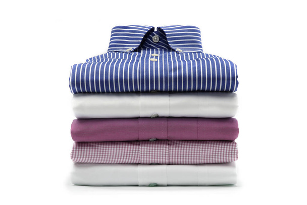 A varicolored plain, checkered and pinstriped folded mens dress shirts isolated over a white background - Photo, Image