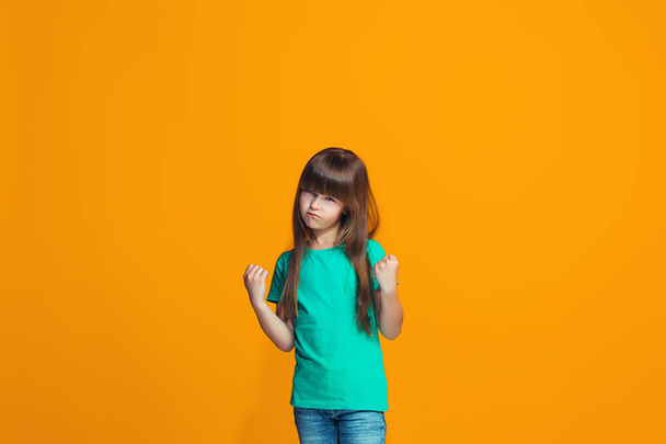 Portrait of angry teen girl on a orange studio background - Foto, Imagen