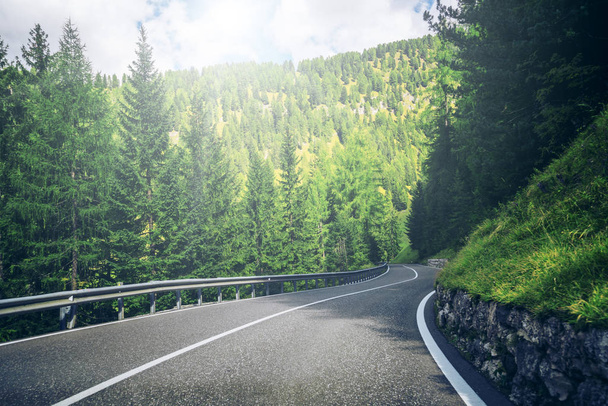 Hermoso camino de montaña con árboles, bosques y montañas en los fondos. Tomado en la carretera estatal de la montaña Dolomitas en Italia
. - Foto, imagen