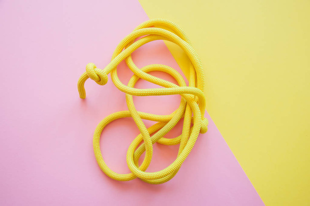 Skipping rope on a pink and yellow background. Top view and copy space. Sport, hobby and lifestyle concept. - Photo, Image