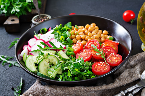 close up of salad of chickpeas, tomatoes, cucumbers, radish and greens, dietary food - Photo, Image