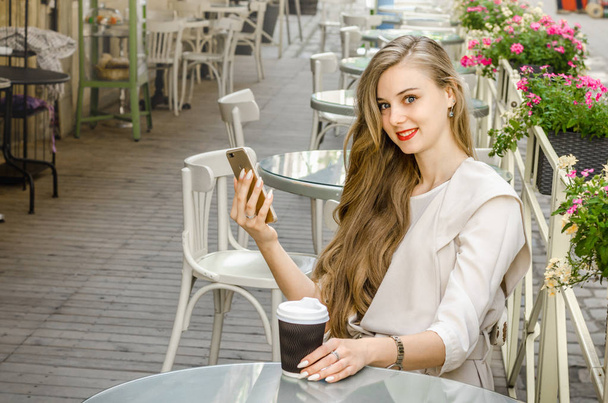 Smiling bussines casual woman holding call smartphone mobile cell with long hair in cafe city street sunny day background - Fotografie, Obrázek