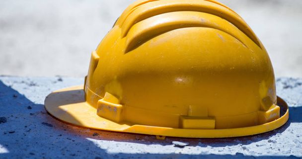 Yellow helmet isolated on a construction site. - Φωτογραφία, εικόνα