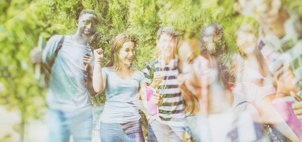 Grupa mieszanej rasy młodzieży szczęśliwy uśmiechający się świeżym powietrzu w ogrodzie. - Zdjęcie, obraz