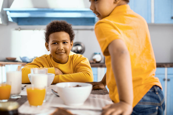 Agradable niño pre-adolescente desayunando con su hermano
 - Foto, imagen