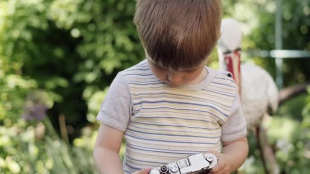 Portrait d'un garçon mignon prenant des photos en plein air sur l'appareil photo vintage
 - Séquence, vidéo