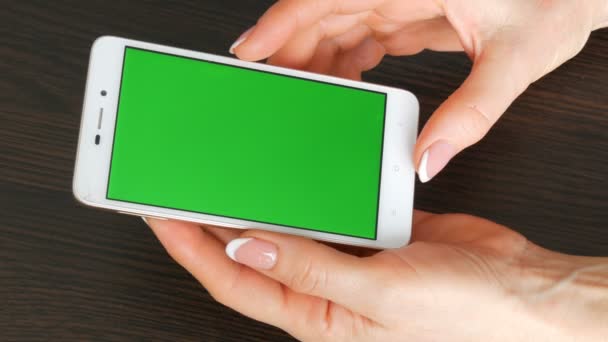 Vrouwelijke handen met prachtige Franse manicure nemen een witte smartphone met Green Screen. Met behulp van de Smartphone, Smartphone met groen scherm te houden - Video
