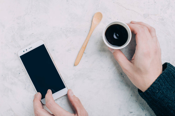 Colheita mãos masculinas segurando café preto em copo descartável e smartphone
 - Foto, Imagem