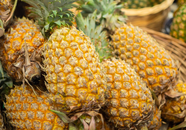 Mucchio di ananas in vendita sul mercato della frutta fresca estiva
 - Foto, immagini