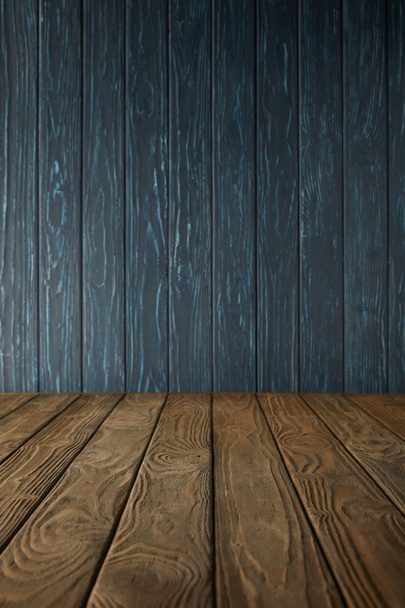 brown wooden table and dark blue wooden wall - Fotoğraf, Görsel