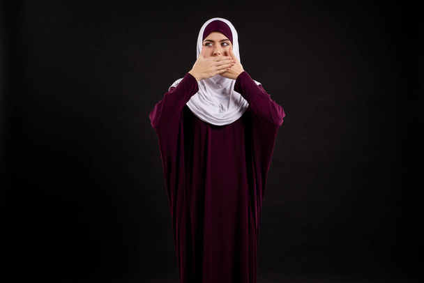 Arab woman in hijab covers mouth with hands. - Fotó, kép