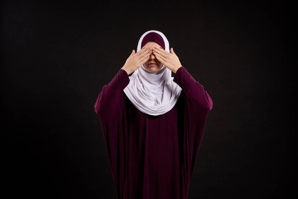 Arab woman in hijab closes eyes with palms. - Photo, Image