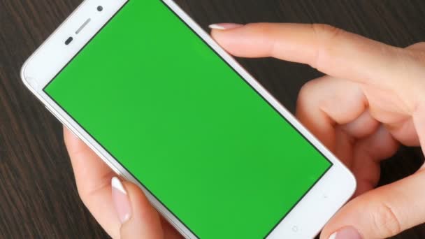 Frauenhände mit schöner französischer Maniküre nehmen ein weißes Smartphone mit grünem Bildschirm. Smartphone benutzen, Smartphone mit grünem Bildschirm halten - Filmmaterial, Video