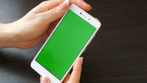 Mãos femininas com manicure francês bonito tomar um smartphone branco com tela verde. Usando Smartphone, Segurando Smartphone com tela verde
 - Filmagem, Vídeo