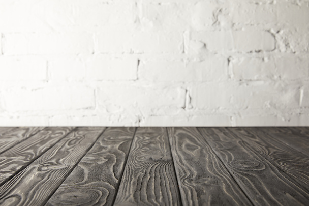 donker grijs houten tafelblad en witte muur met bakstenen - Foto, afbeelding