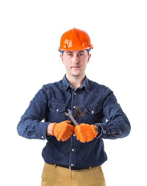 reparador (construtor) em capacete e com uma chave ajustável na mão isolado em fundo branco
 - Foto, Imagem