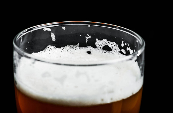 piana osadza się w piwo Kraft piwo w szklance na czarnym tle - Zdjęcie, obraz