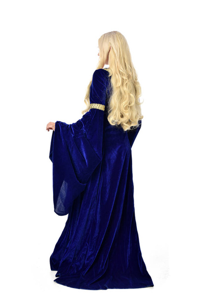 full length portrait of pretty blonde lady wearing  a blue fantasy medieval gown. standing pose on white background. - Photo, Image