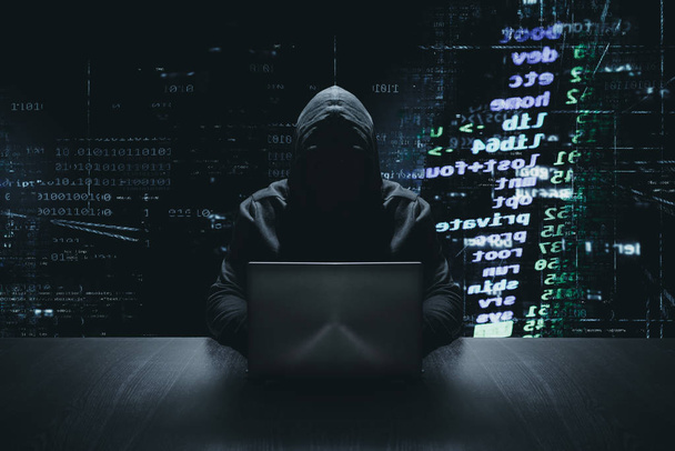 Hacker anônimo com seu computador na frente de fundo de código binário
 - Foto, Imagem