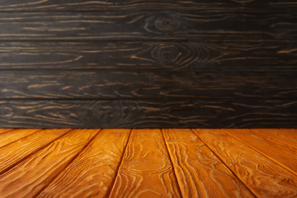 orange striped tabletop and dark wooden wall - Foto, Imagem