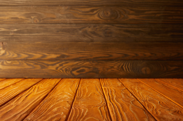 orange striped tabletop and brown wooden wall - Fotoğraf, Görsel