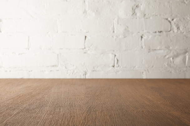 hnědá dřevěná stolní a bílá zeď s cihly - Fotografie, Obrázek