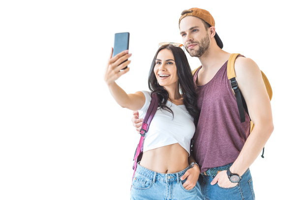 happy couple of tourists taking selfie on smartphone, isolated on white - Photo, Image