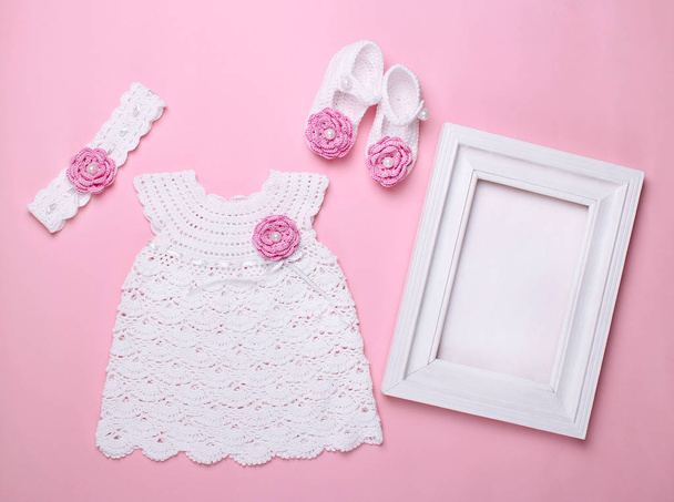 όμορφο μωρό φόρεμα με μποτάκια σε ροζ φόντο - Φωτογραφία, εικόνα