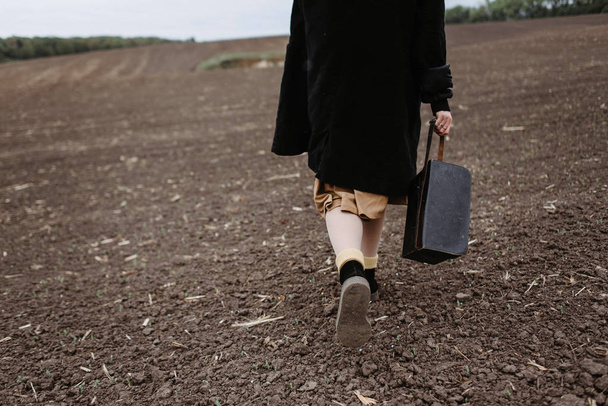寒い天候下でのフィールドで歩いているスカートの女性の低断面図 - 写真・画像