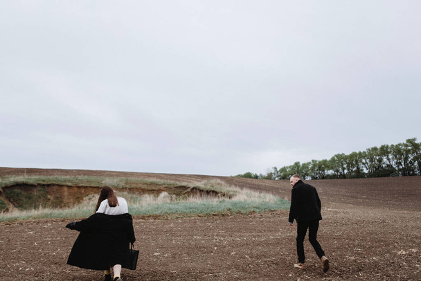 Vista trasera de la pareja caminando juntos por el prado
 - Foto, imagen