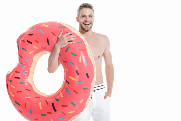 smiling man in swimwear with inflatable donut, isolated on white - Фото, изображение