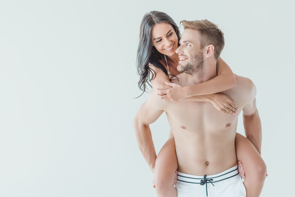 handsome man piggybacking his happy girlfriend, isolated on white - Фото, зображення