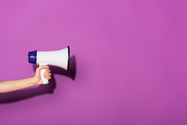 cropped image of woman holding megaphone on purple background  - Foto, imagen